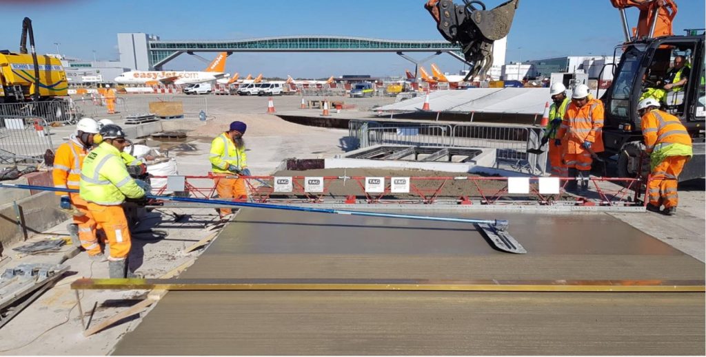 TAG crew placing and levelling concrete on an apron at Gatwick Airport