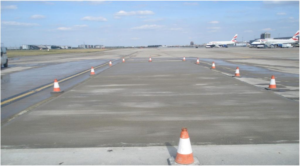 New concrete bays on the apron at London City Airport with aircraft in the background