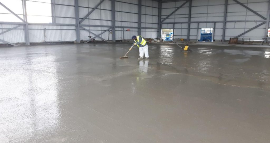 Operative finishing the concrete floor of the search and rescue hangar at Lydd Airport