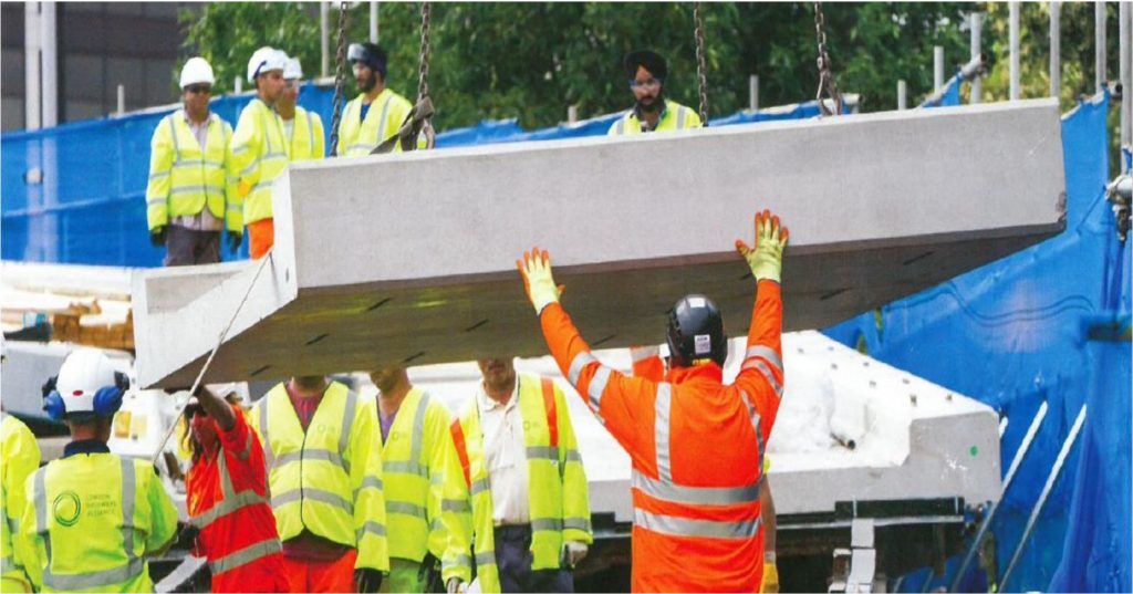 Team guiding a precast concrete unit into place at the Power Road bridge